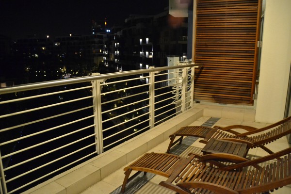 A varanda é dividida em dois ambientes: um com estas espreguiçadeiras e outro com mesa e cadeiras do mesmo material